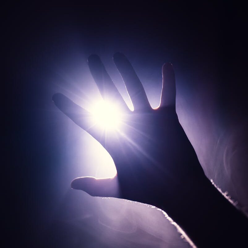 purple toned back lit photo of a hand