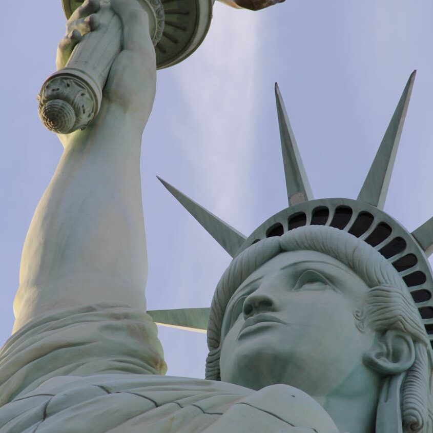 statue of liberty under blue skies